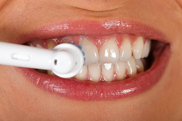 Close up picture of a young woman's beautiful denture while theeth-brushing